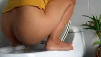 Young woman defecating in the bathroom