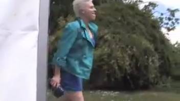Girl with cropped hair urinating on the path
