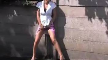 Attractive young woman urinating behind a barrier