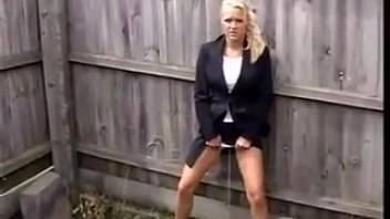 Attractive slim blond woman urinating in the backyard